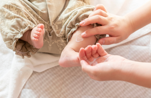保湿剤を塗られる赤ちゃんの足